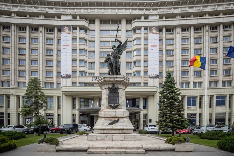 Fațada JW Marriott Bucharest Grand Hotel, cu bannerele congresului SSER și monumentul din fața intrării.