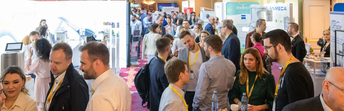 Pauza dintre sesiuni: mulțime de participanți între standurile expoziției.