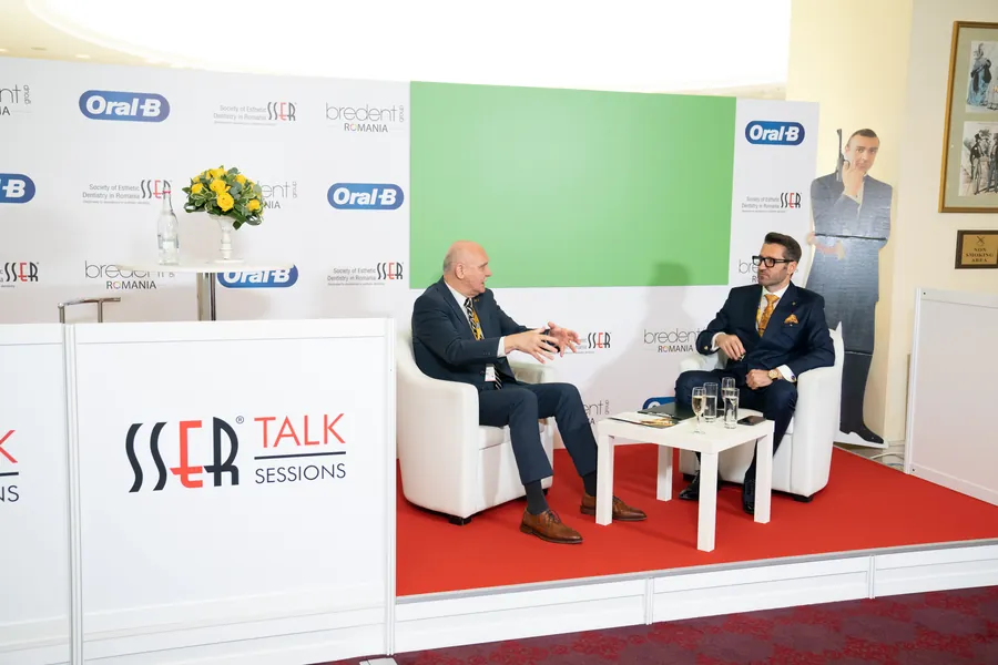 Studioul SSER Talk Sessions: doi medici în fotolii albe, pe un covor roșu, în fața camerelor.
